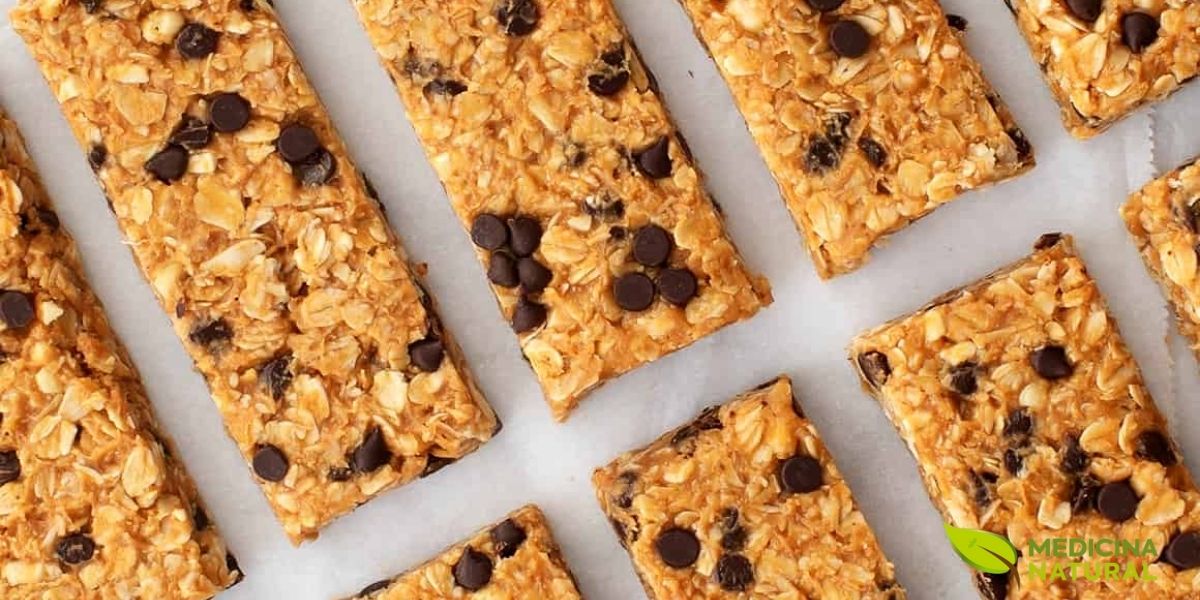 Barras de granola caseiras cortadas em porções uniformes e perfeitamente alinhadas sobre papel manteiga branco, demonstrando a técnica adequada de preparação e apresentação. A imagem exemplifica o resultado final de uma receita bem executada de barras de proteína pelo método a frio, onde a textura firme mas não dura permite cortes limpos e precisos. Barras de granola caseiras cortadas em porções uniformes e perfeitamente alinhadas sobre papel manteiga branco, demonstrando a técnica adequada de preparação e apresentação. A imagem exemplifica o resultado final de uma receita bem executada de barras de proteína pelo método a frio, onde a textura firme mas não dura permite cortes limpos e precisos.