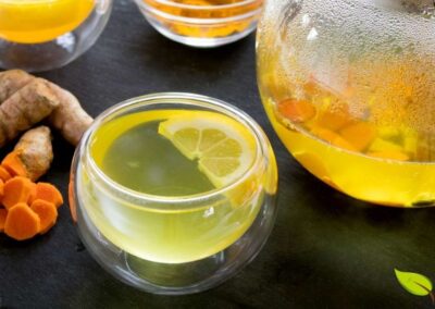 Xícara de chá de cúrcuma tradicional em tom amarelo dourado intenso sobre superfície clara. Esta infusão simples e poderosa é preparada com raiz de cúrcuma fresca ou em pó, água quente, pimenta-do-reino e uma fonte de gordura saudável para maximizar a absorção da curcumina. Perfeito para consumo diário como anti-inflamatório natural.