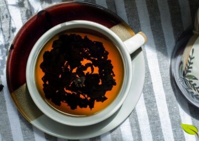 O chá preto, totalmente oxidado, apresenta características visuais e organolépticas completamente diferentes do chá verde, embora ambos provenham da mesma planta Camellia sinensis. As folhas escuras e a infusão âmbar profundo são resultado da oxidação completa, processo que converte as catequinas em teaflavinas e tearubiginas, compostos que conferem ao chá preto seu sabor robusto, maltado e ligeiramente adstringente. O teor de cafeína é geralmente mais alto que no chá verde.