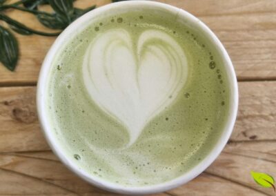 Estudos científicos demonstram que o consumo regular de 2 a 3 xícaras diárias pode reduzir significativamente o risco de hipertensão arterial. As catequinas presentes no chá verde, especialmente a epigalocatequina-3-galato (EGCG), atuam melhorando a função endotelial dos vasos sanguíneos, promovendo o relaxamento vascular através da produção de óxido nítrico. Esta imagem simboliza o ritual diário que pode contribuir para a manutenção de uma pressão arterial saudável e a proteção do sistema cardiovascular.