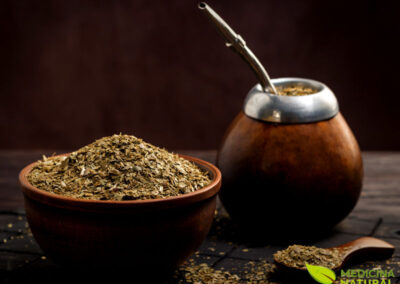 Uma cuia de madeira cheia de erva-mate e uma bomba de metal, pronta para o preparo do chimarrão. Esta cena evoca a tradição e o ritual social associados ao consumo de erva-mate na América do Sul, um símbolo de hospitalidade e comunhão.