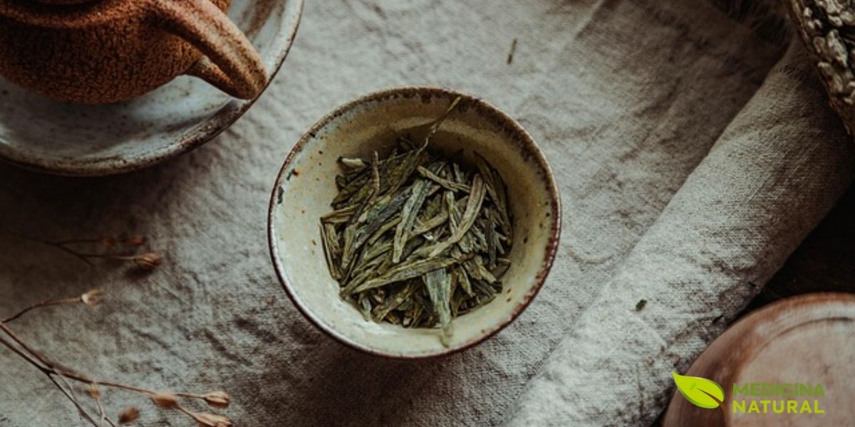 Folhas de chá verde secas em tigela de cerâmica mostram a textura e cor características do processamento japonês. As folhas do Bancha são maiores e mais irregulares que as do Sencha, refletindo sua origem de colheitas tardias e seu caráter robusto.