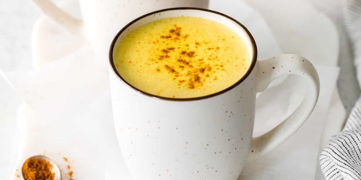 Golden Milk vegano finalizado, mostrando a textura cremosa e cor dourada característica. Esta versão utiliza leite vegetal (amêndoas, coco ou aveia) como base, tornando a bebida adequada para dietas plant-based sem comprometer os benefícios terapêuticos da cúrcuma.