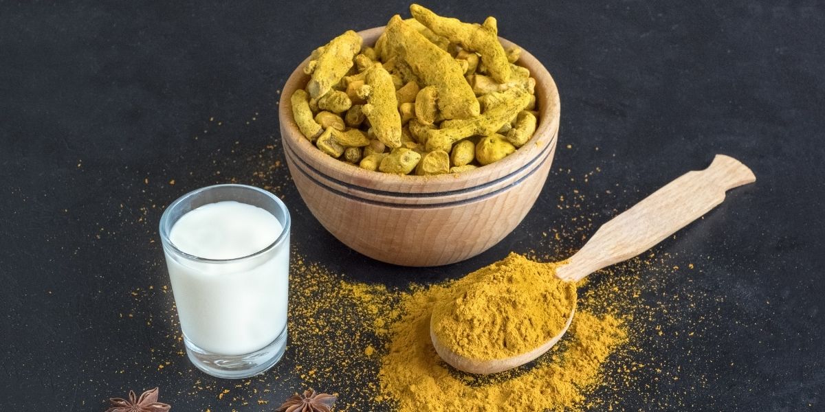 Composição com ingredientes essenciais para preparar chá de cúrcuma: raiz fresca, pó dourado, pimenta-do-reino e especiarias aromáticas. Esta imagem ilustra os componentes necessários para maximizar a biodisponibilidade da curcumina, incluindo a piperina da pimenta que aumenta a absorção em até 2.000%.