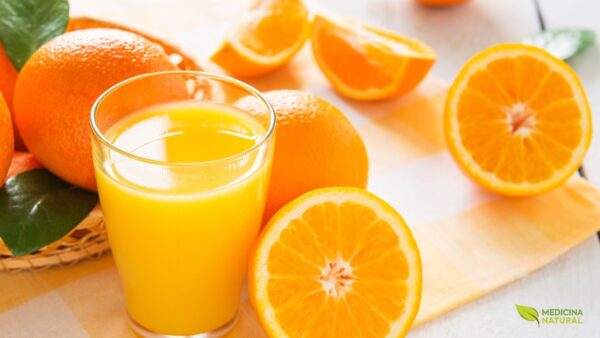 Suco de laranja fresco com laranjas ao lado