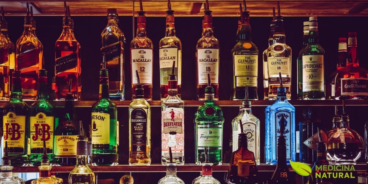 A ampla disponibilidade e variedade de bebidas alcoólicas na sociedade moderna contribui significativamente para o desenvolvimento do alcoolismo. Esta imagem mostra a diversidade de destilados disponíveis comercialmente, desde whiskies premium até vodkas e gins. A indústria do álcool movimenta bilhões globalmente, mas o custo social e de saúde pública é imenso. No Brasil, cerca de 10% da população sofre com alcoolismo, sendo que o consumo excessivo está relacionado a mais de 200 doenças e condições de saúde. Compreender os riscos associados ao consumo de álcool é o primeiro passo para a prevenção e tratamento natural eficaz.